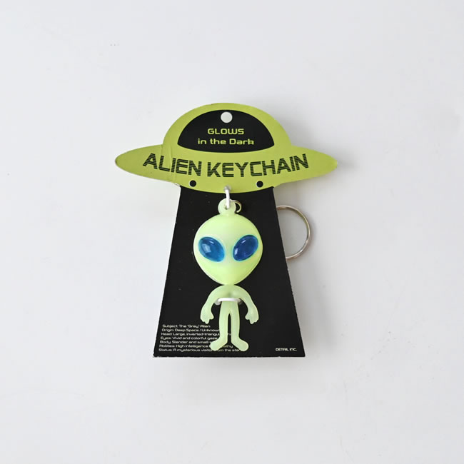 UFOから降りてくる場面を表現した台紙にセットされたエイリアン キーチェーン