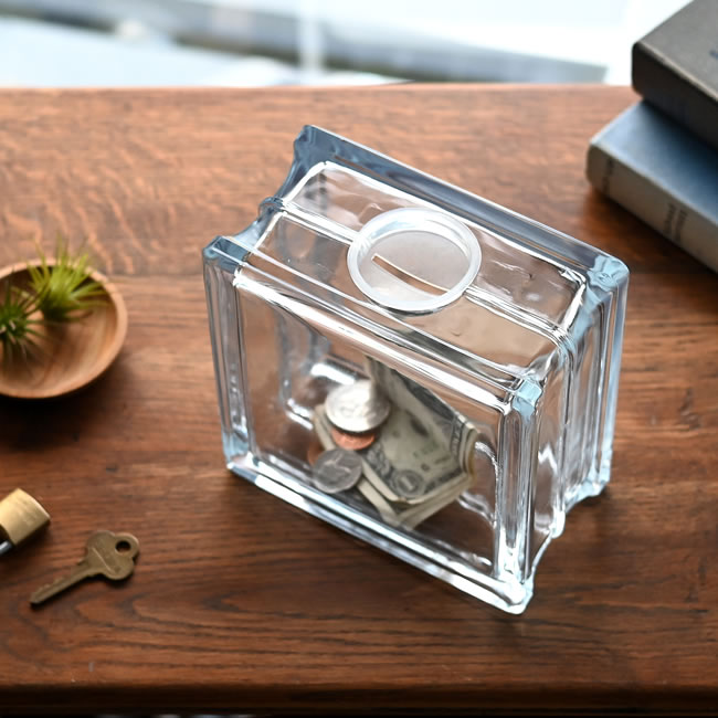 上部の投入口と取り外しできるキャップが付いたガラス製の貯金箱