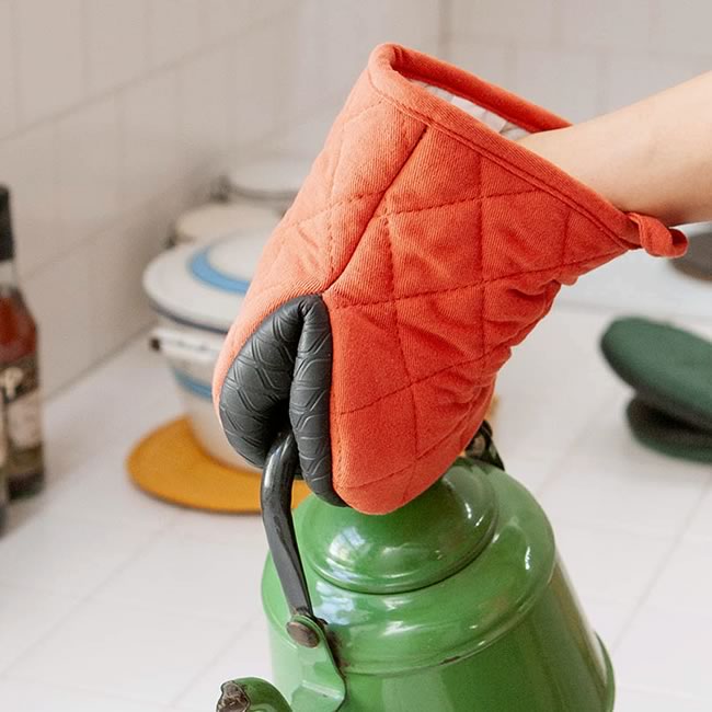  
オレンジ色のオーブンミットでケトルを持つ様子 