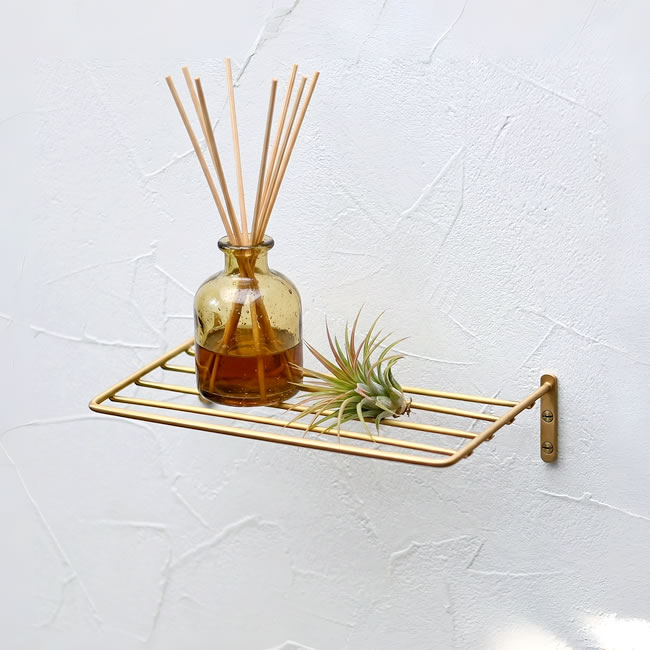 真鍮の風合いが美しい壁付けワイヤーシェルフにディフューザーを置いた使用イメージ