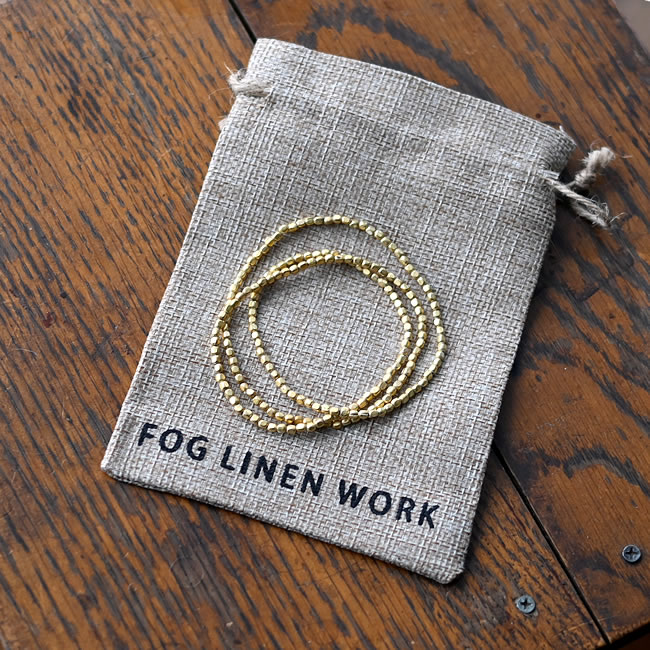 巾着に入ったブラスビーズネックレス