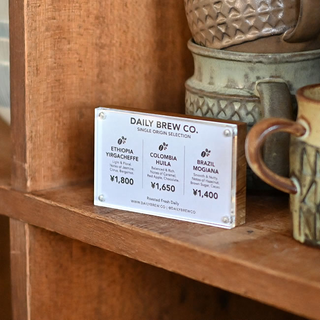 コーヒーの価格表を挟み、陶器のカップと並べたカードホルダー