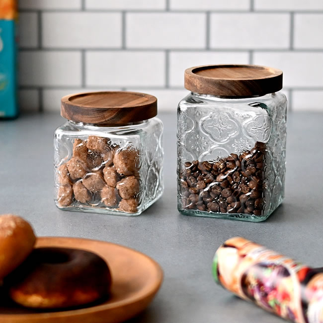 フローラ柄のレリーフが入ったガラスキャニスターSとLにナッツとコーヒー豆を入れて並べた様子