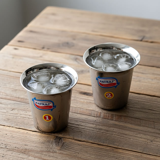  
木のテーブルに並んだ氷入りのステンレスチャイカップ 