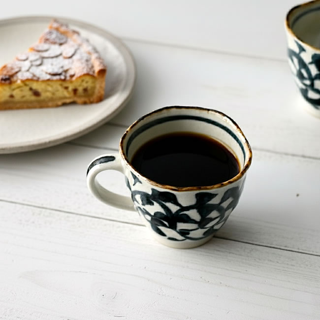  
たこ唐草模様のマグカップにコーヒーを注ぎ、ケーキを添えたテーブルシーン 