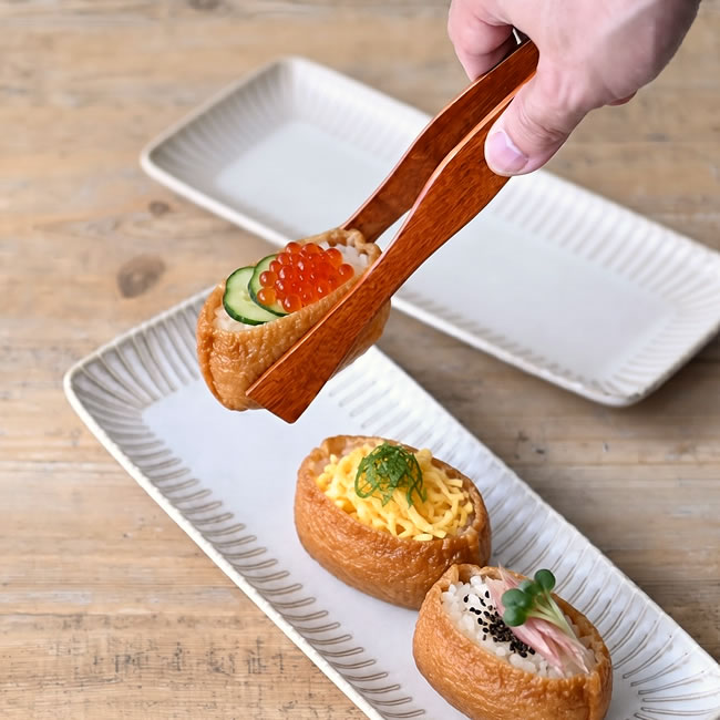 WOOD トングでいくらときゅうりをのせたいなり寿司を盛り付ける様子
