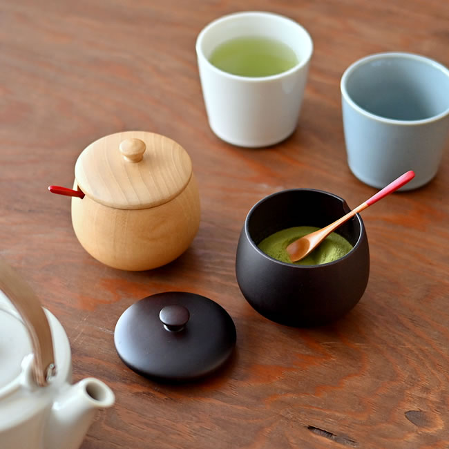 木製の丸い薬味入れと湯のみが並ぶ卓上風景