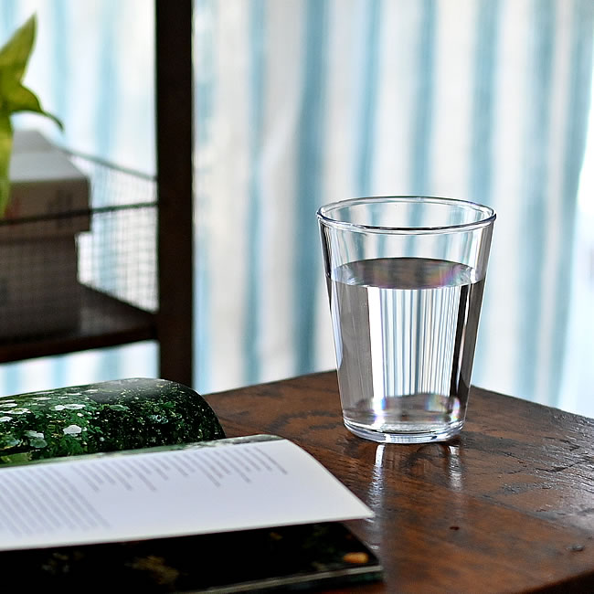 木のテーブルに置かれた透明な壊れないグラス