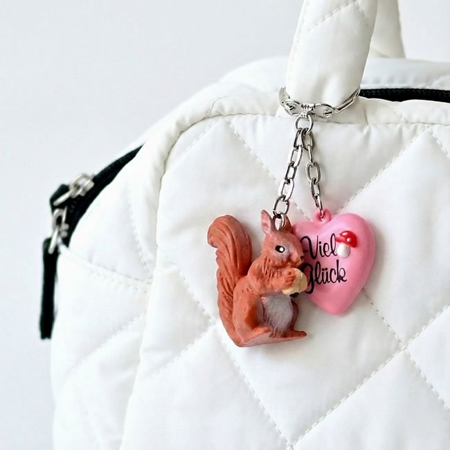  
白いキルティングバッグに付けたリスのキーホルダー チャーム付き 