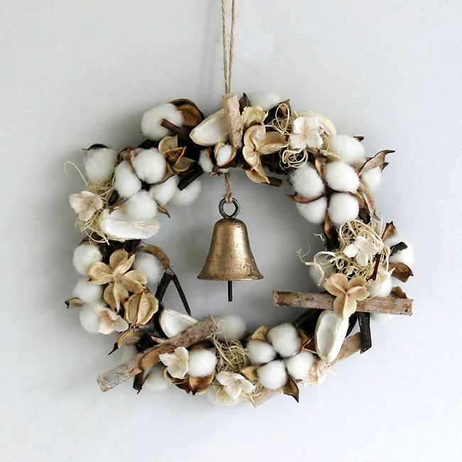  
コットンと木の実のリースに吊るされたアイアンベル 
