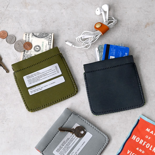 紙幣やカード、鍵、イヤホンと一緒に置かれたコイン＆カードホルダーの使用イメージ