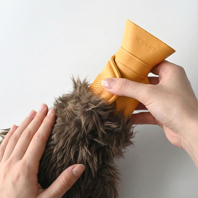  
湯たんぽをファーカバーへ差し込む様子 