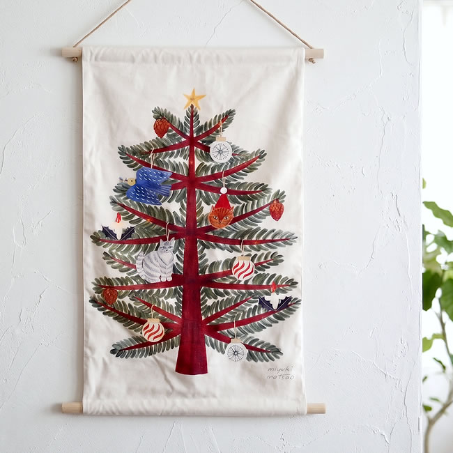 灯りを消したタペストリーに描かれた猫や鳥とクリスマスツリー