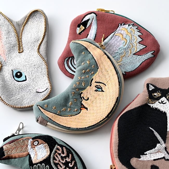白うさぎ、スワン、ムーン、黒ネコ、オオハシの刺繍ポーチを並べたイメージ