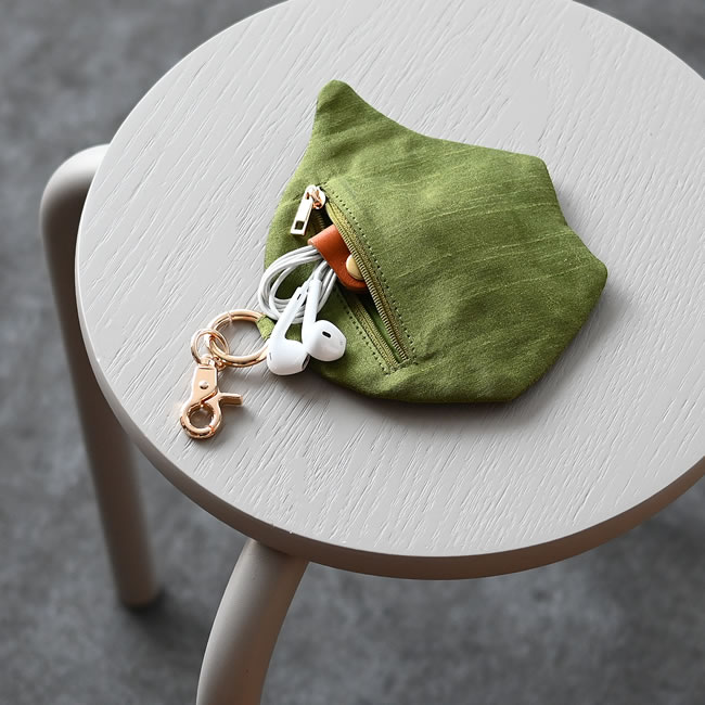 イヤホンを収納した魚モチーフ刺繍キーポーチの使用イメージ