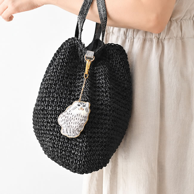 黒いかごバッグに付けた猫モチーフのザリ刺繍キーホルダー