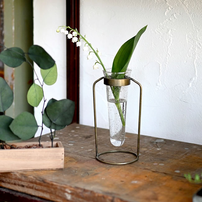 真鍮スタンドにストーン調ガラスベースを合わせたフラワーベースにスズランを飾った様子