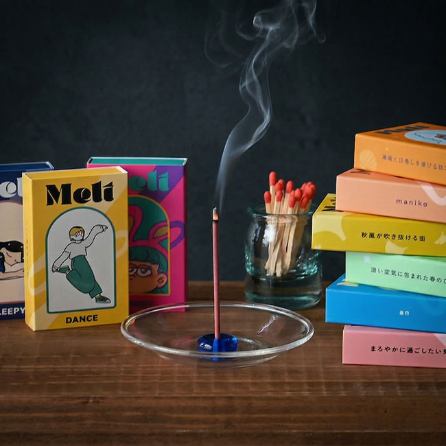 煙が立ちのぼるお香と本のある落ち着いたシーン